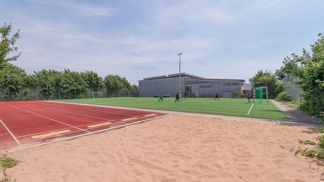 Sports field for football and athletics with a sand pit